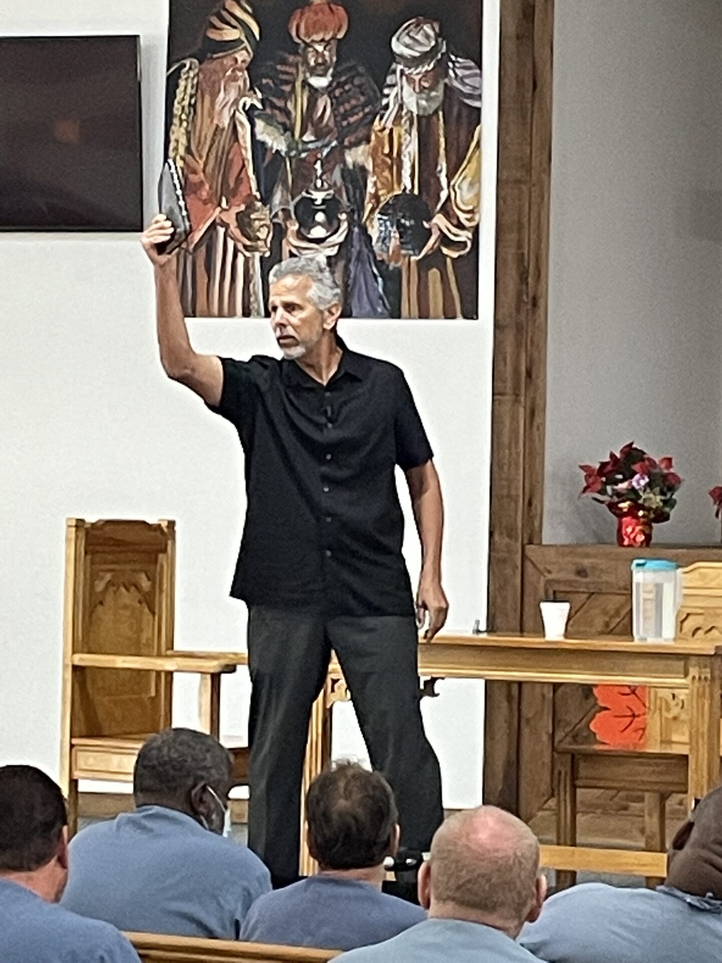 A man in black shirt holding up his hand.