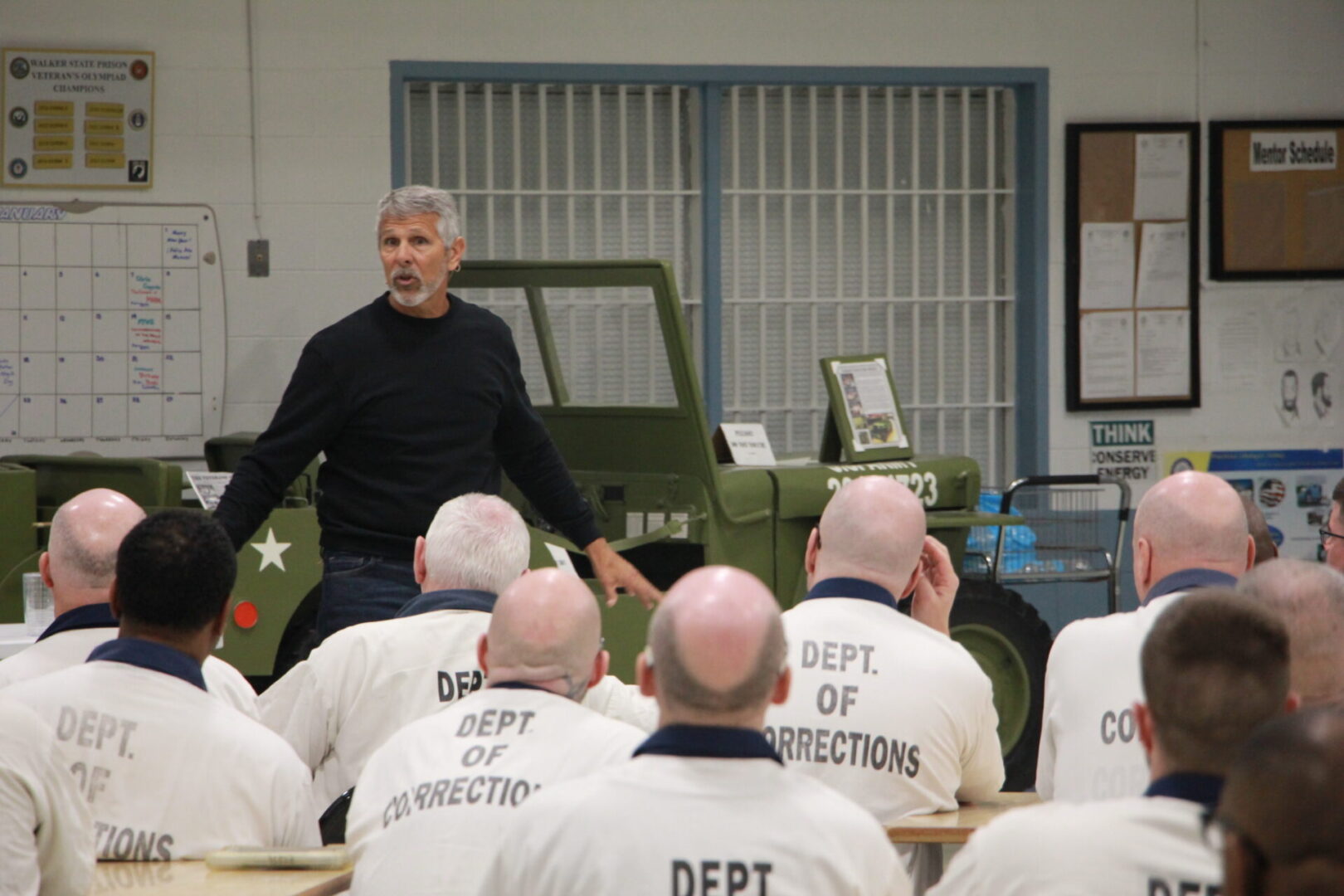 A man in black shirt standing next to group of men.